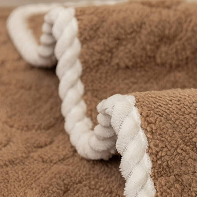 Close-up of beige dotted textured fabric edge of blanket showing raised dots and weave.